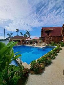 a large blue swimming pool next to a house at Melasti Mountain Villas Amed in Amed