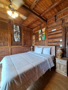 a large bed in a room with wooden walls at Melasti Mountain Villas Amed in Amed +17 photos