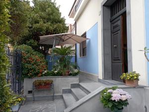 a porch with a bench and an umbrella at B&B Betania in Riposto