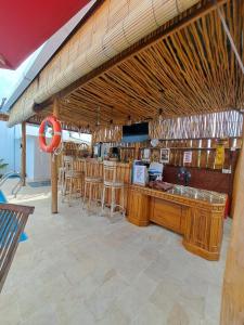a restaurant with a bar with wooden tables and chairs at Melasti Mountain Villas Amed in Amed