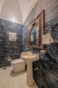 a bathroom with a sink and a toilet and a mirror at Hotel Shahi Palace Mandawa in Mandāwa