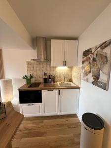 Una cocina con gabinetes blancos y un fregadero. en Zen Studio Marina Deauville Vue Mer - Design Chic, en Deauville