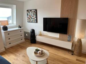 a living room with a large flat screen tv at Zen Studio Marina Deauville Vue Mer - Design Chic in Deauville +10 photos