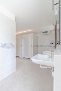 un bagno bianco con due lavandini e una vasca di AgriCamping Ca' Bodi a Cavallino-Treporti