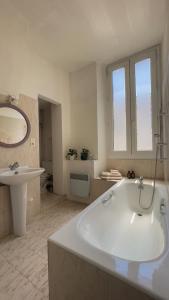 une salle de bain blanche avec une baignoire et un lavabo dans l'établissement Paradis, an Architect duplex in Vauban area, à Marseille 12 autres photos