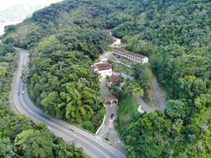 an aerial view of a house on a hill next to a road at Ubatuba's Surf hotel in Ubatuba +4 photos