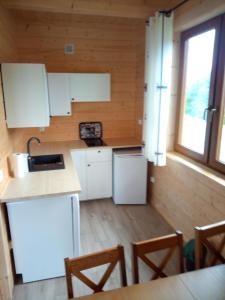 a kitchen with white cabinets and wooden walls at Słoneczna Chata dom Kasina Wielka in Kasina Wielka