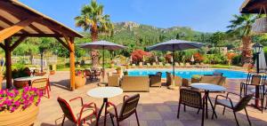 a patio with tables and chairs next to a pool at Phivos Hotel in Paleokastritsa