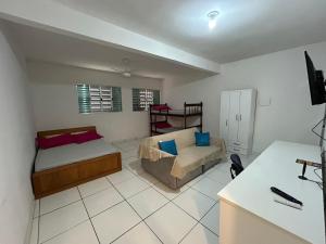 a bedroom with a bed and a couch and a desk at Studio Cotia Centro próximo ao Animalia Park CT do São Paulo Thermas da Mata Shopping Central Park in Cotia