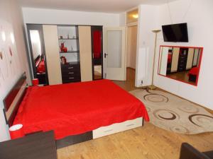 1 dormitorio con cama roja y manta roja en Studio Lujerului Bucuresti, en Bucarest