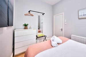 a bedroom with a bed and a dresser and a mirror at West Beach 1 - dog friendly - Portrush by the Sea in Portrush