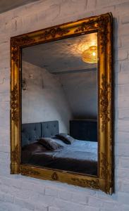 uno specchio a parete con un letto. di beApart a Ypres