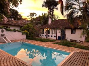 a swimming pool in front of a house at Chalé Segredo da Serra in Tiradentes
