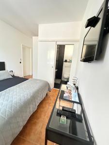 a bedroom with a bed and a table with a tv at Apartmani Vernissage in Biograd na Moru