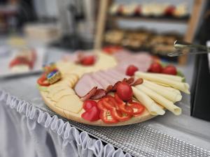 a plate of food with meats and cheese on a table at Willa Anavill in Mielno +43 photos