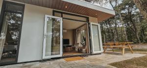 a house with large sliding glass doors on a patio at Elly's Broekhuisje in Haarle