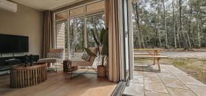 a living room with a sliding glass door to a patio at Elly's Broekhuisje in Haarle