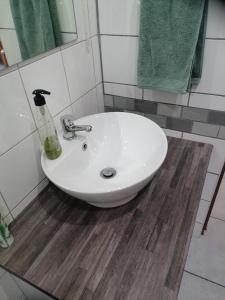 a white sink in a bathroom with green towels at Darize Self Catering Flat in Kimberley