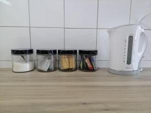 a counter with four containers of food and a toaster at Darize Self Catering Flat in Kimberley +9 photos