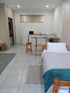 a room with two beds and a kitchen at Darize Self Catering Flat in Kimberley