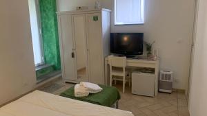 una habitación con una cama, un escritorio y un televisor en B&B Campagna Casagrande, en Recco
