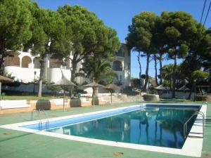 una piscina frente a una casa con árboles en Alpen1 Residencial Finca del Moro en Peñíscola