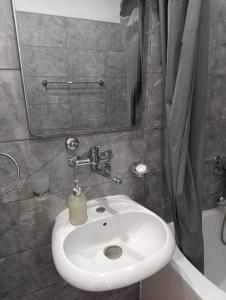 a bathroom with a white sink and a mirror at Apartman Maja in Bijeljina +28 photos