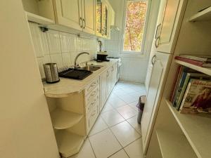 a white kitchen with a sink and a refrigerator at Castle Hill Hideaway in Budapest +1 photo