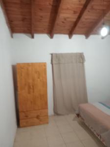 una camera da letto con un letto e una porta di legno di Dpto en San Luis Capital a San Luis