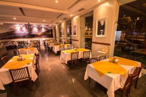 a restaurant with tables and chairs with yellow table cloth at Aipana Plaza Hotel in Boa Vista