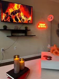 a living room with a fireplace with candles and a tv at Cozy King 2 bedroom at Easton near Airport in Columbus