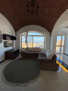 a living room with a couch and a large window at Crystal waves in Hurghada