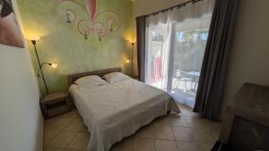 a bedroom with a bed and a large window at Les Geckos in Saintes-Maries-de-la-Mer