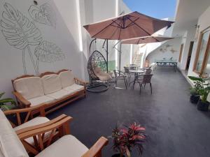 a living room with a couch and a table with an umbrella at Ravenala Paracas Hostel & Apartment in Paracas