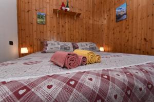a bed with blankets and towels on top of it at Appartamento Ca' Battaglia in Chiesa in Valmalenco