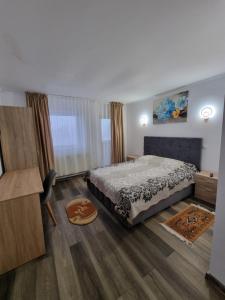 a bedroom with a bed and a wooden floor at Vila Roxana Busteni in Buşteni