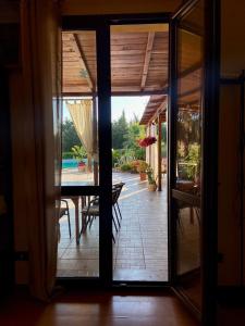 an open glass door to a patio with a table at Tenuta Seredipà in Castellammare del Golfo