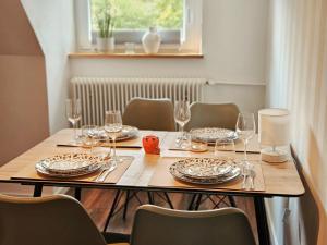 a dining room table with glasses and plates on it at Dachnest mit Terasse & Sauna in Oerlinghausen