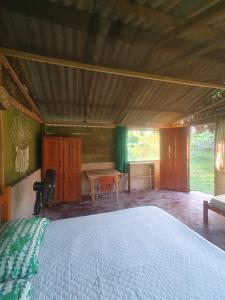 a bedroom with a large bed and a table at Centro de Medicina y Posada Indigenawa in Cruzeiro do Sul