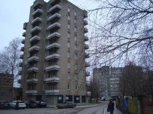 un edificio de apartamentos alto en una calle con coches aparcados en Hotel Han Krum en Targovishte