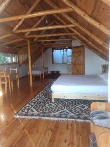 a room with a bed and a table and chairs at Matsunoki in Karakol