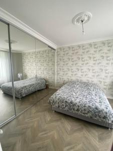 a bedroom with two beds and a mirror at Villa Les Tourelles in Flers