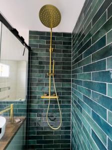 a bathroom with a shower with blue tiles at Studio rénové proche de la plage in Tarnos +2 photos