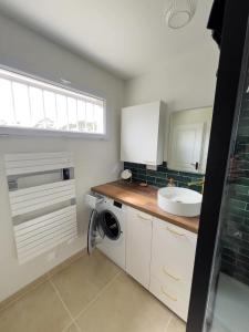 a kitchen with a sink and a washing machine at Studio rénové proche de la plage in Tarnos