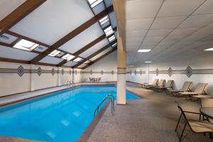 堪薩斯城的住宿－Best Western Premier Kansas City Sports Complex Hotel，一个带椅子的房间的游泳池和一个大型游泳池