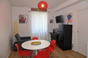 a living room with a white table and red chairs at Casa Nova Luxury Apartment Suite Limoni in Nova Milanese