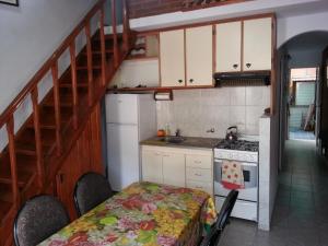 een keuken met een trap, een tafel en een fornuis bij MaJoMi Toninas in Las Toninas