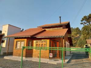 a small house is shown behind a fence at Super Casa de 3 Quartos ao Lado da Igreja Matriz in Urubici
