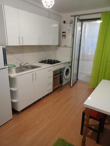 a kitchen with white cabinets and a sink and a stove at Apartament luxury in Floreşti