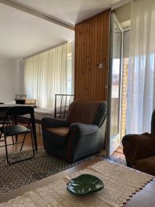 a living room with a chair and a table at Sunlit City Apartment Gjakova in Gjakove